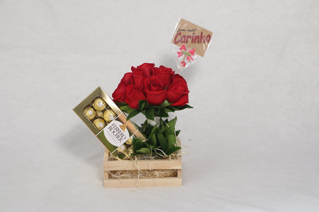 A wooden box with red roses, chocolates, and a caring message on white background.